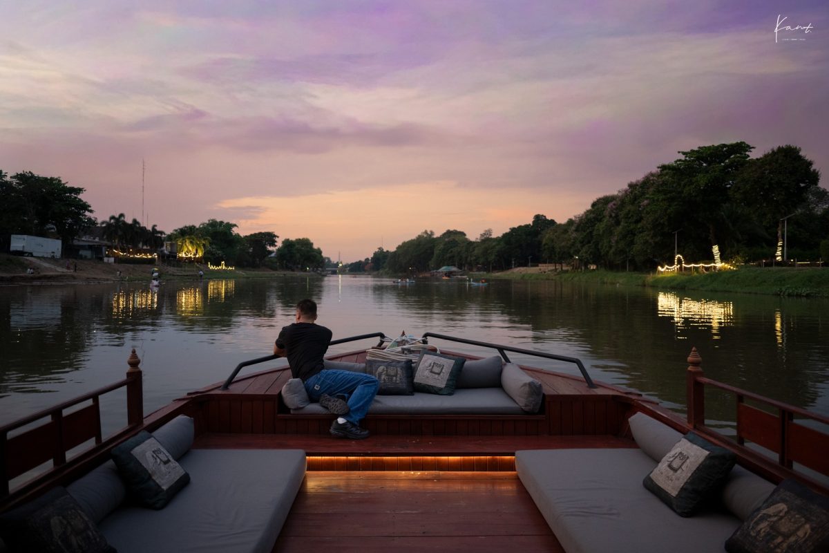 ผู้เข้าพักนั่งบนเรือล่องแม่น้ำปิงยามพลบค่ำ