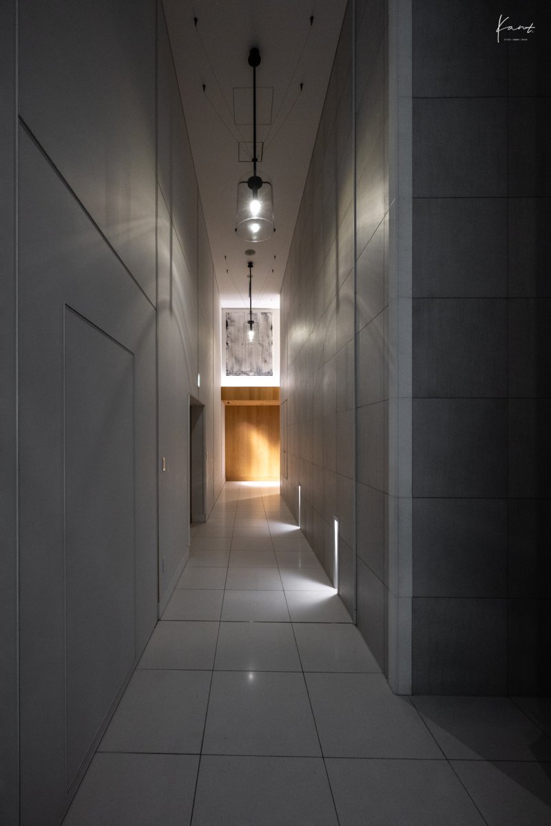 ทางเดินสีขาวอมเทาไปยังห้องทรีตเมนต์ของ AO Spa