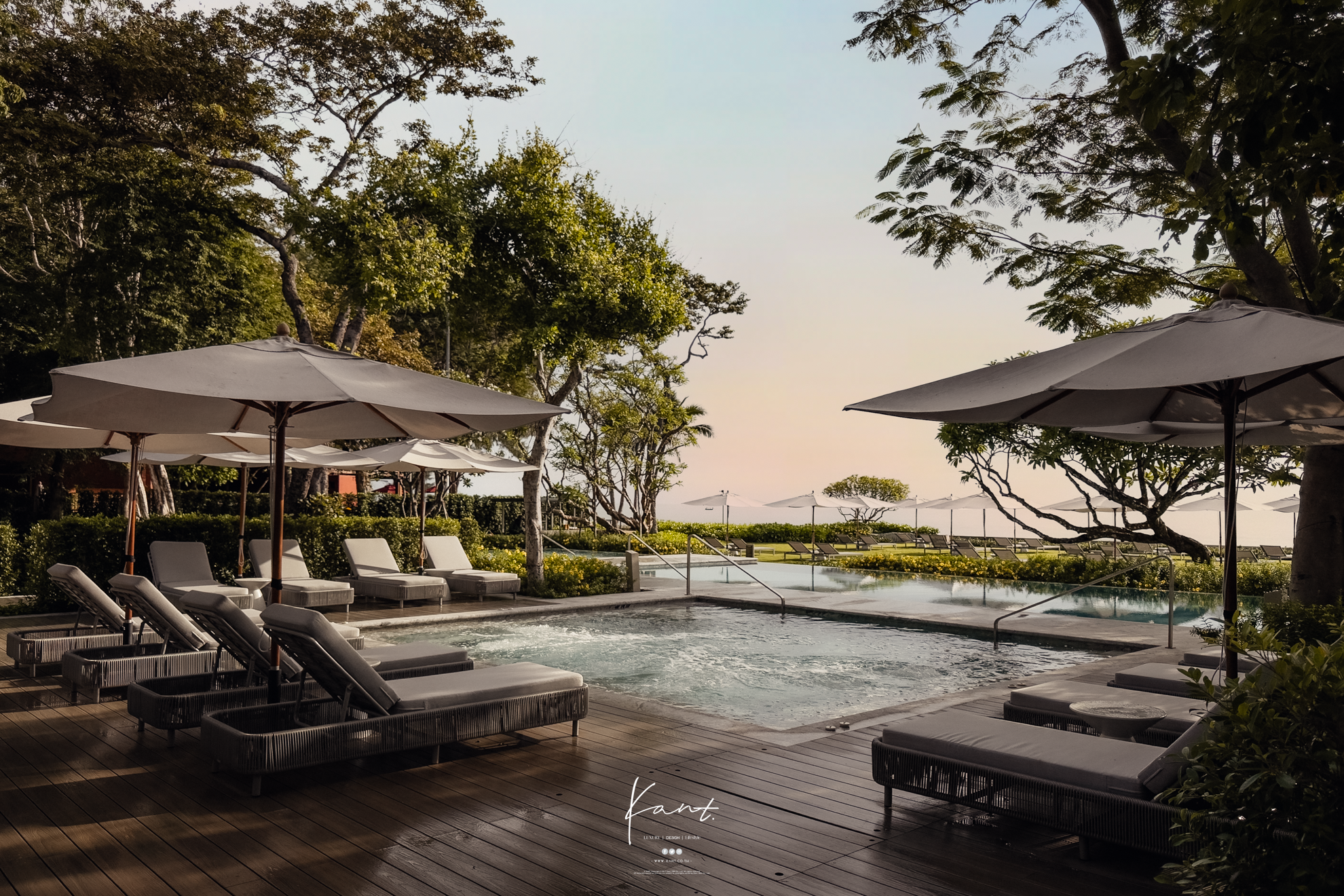สระว่ายน้ำริมหาดกับเตียงพักใต้ร่มในแสงเย็นของ THE BARAI HUA HIN