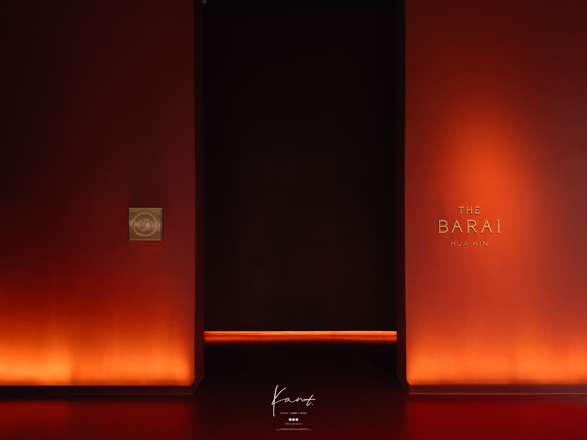 ผนังสีแดงเข้มติดตราสัญลักษณ์ THE BARAI ในแสงอุ่น