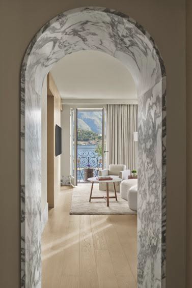 โถงทางเข้าหินอ่อนของ Loft Suite ที่ The Lake Como EDITION มองทะลุไปยังระเบียงริมทะเลสาบ
