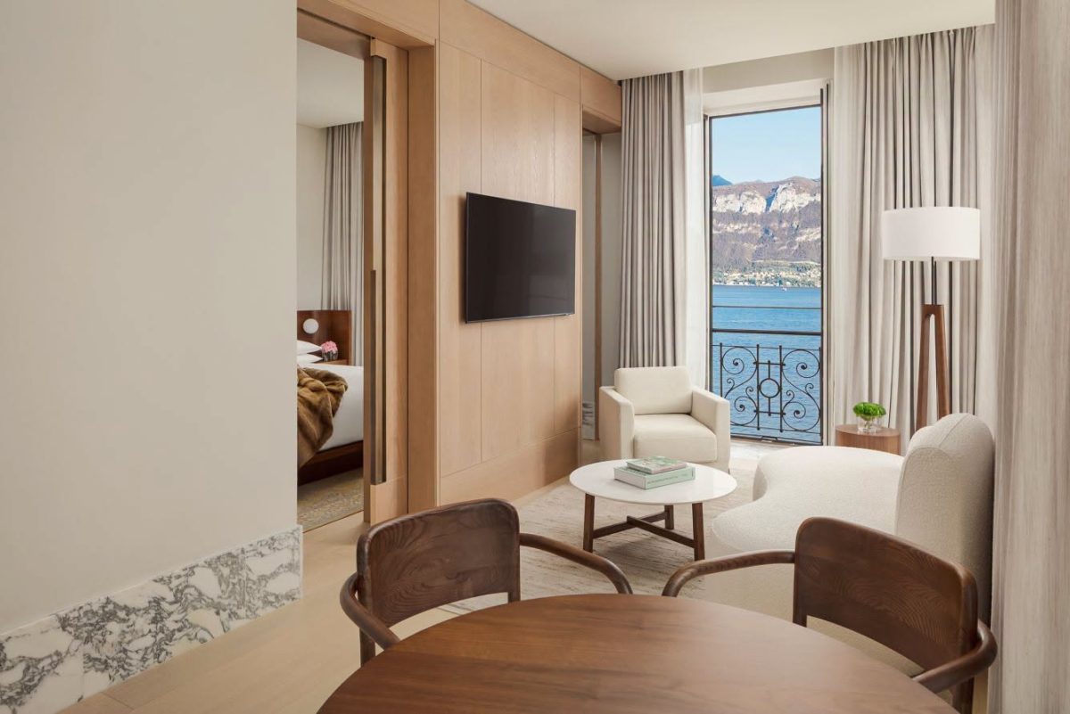 มุมนั่งเล่นใน Loft Suite ของ The Lake Como EDITION พร้อมประตูเปิดรับวิวทะเลสาบ