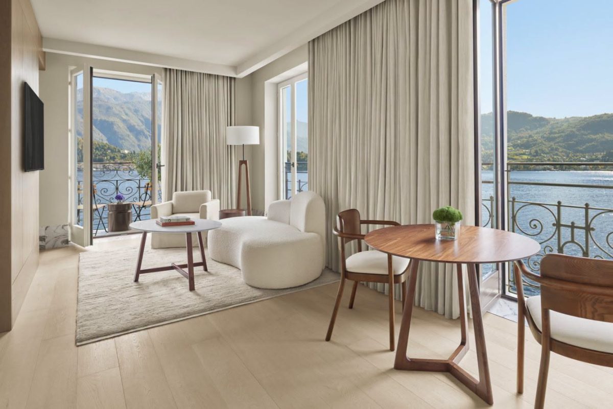 ห้องนั่งเล่นของ Loft Suite ที่ The Lake Como EDITION กับโต๊ะไม้วอลนัตและวิวทะเลสาบ