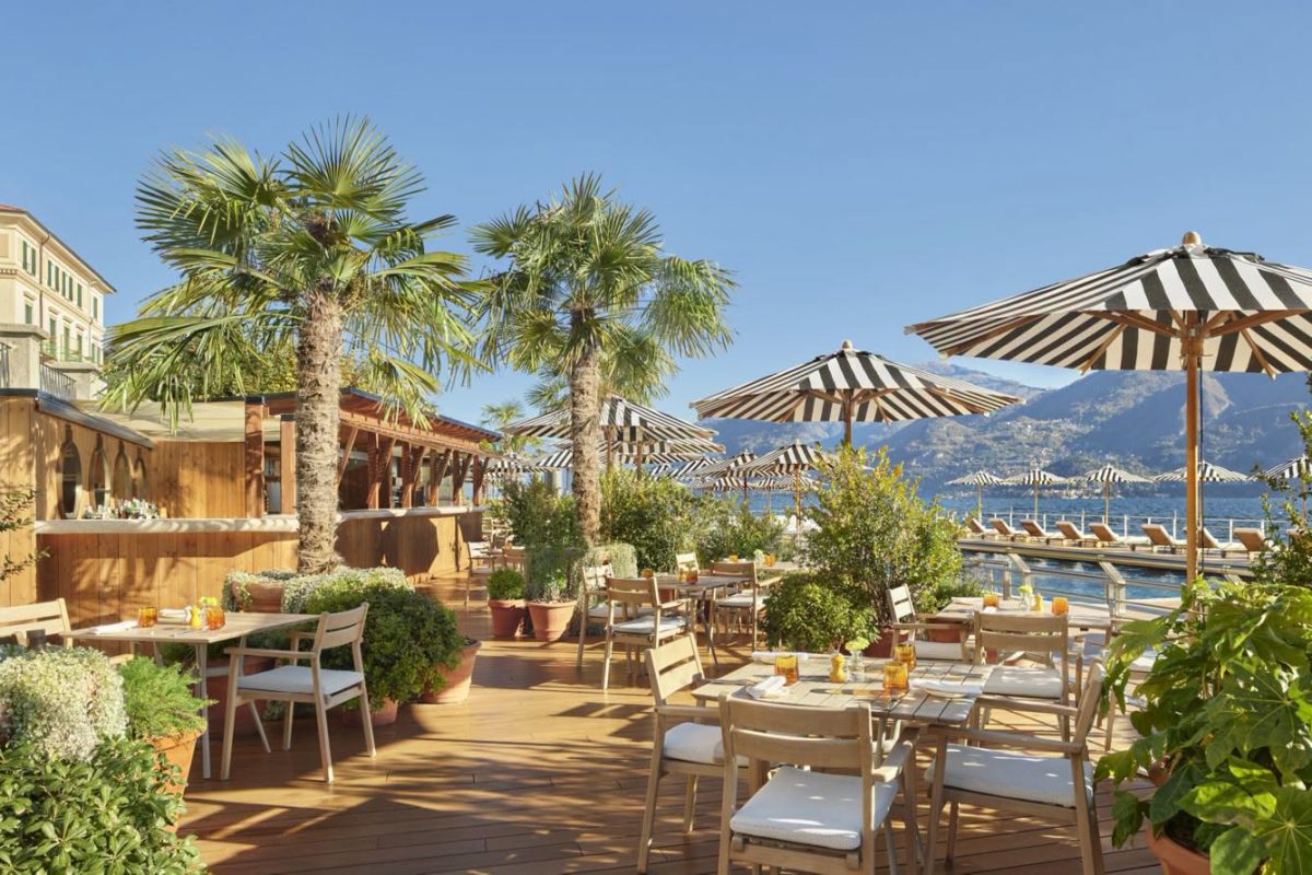 บาร์ริมสระไม้ของ The Lake Como EDITION กับต้นปาล์มและร่มลายทางขาวดำ