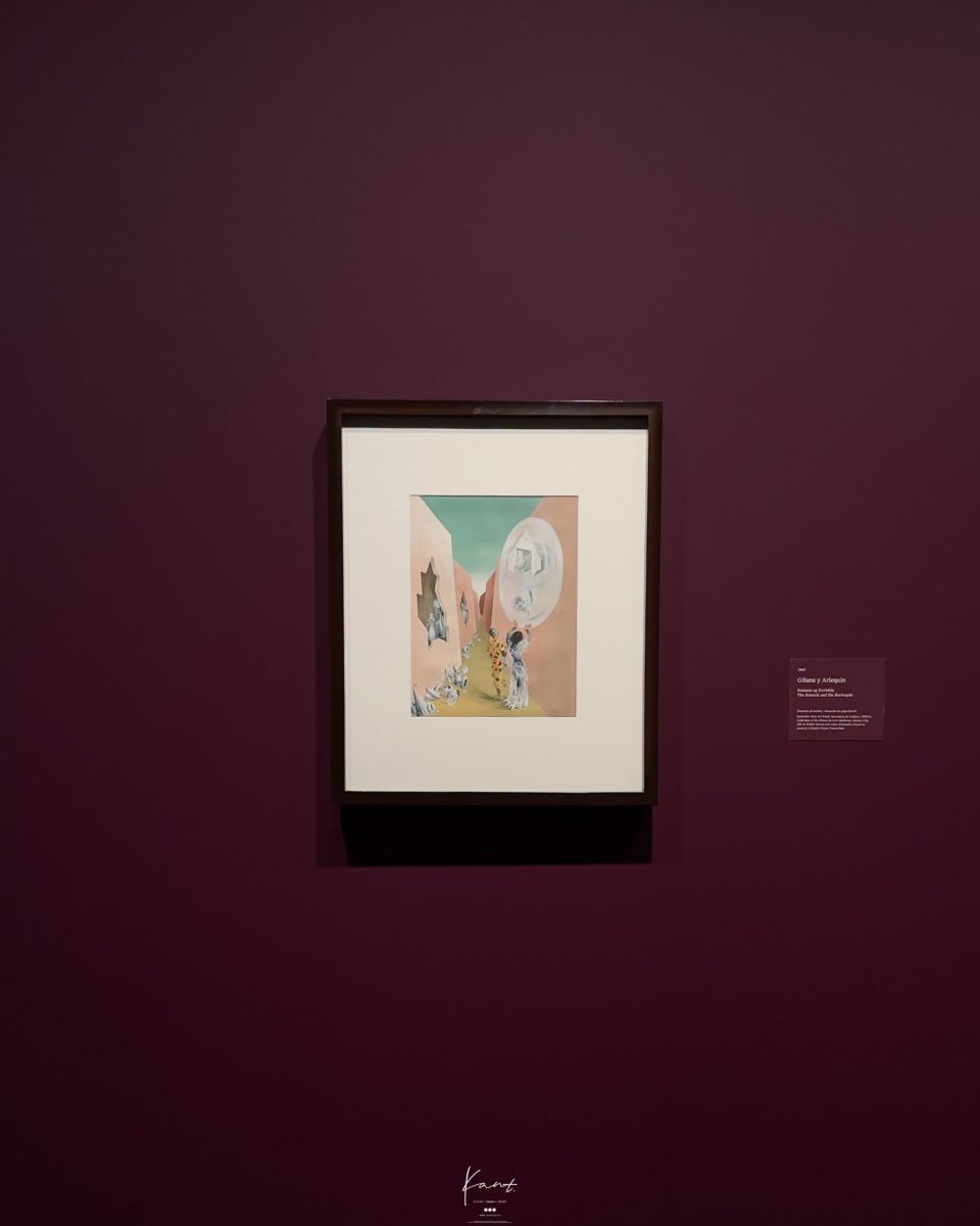 ภาพวาดเหนือจริงใส่กรอบบนผนังสีม่วงเข้มในห้องนิทรรศการ